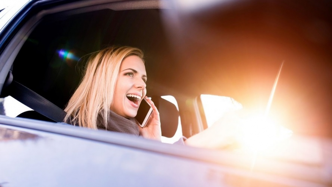 Woman talking on mobile phone while driving.